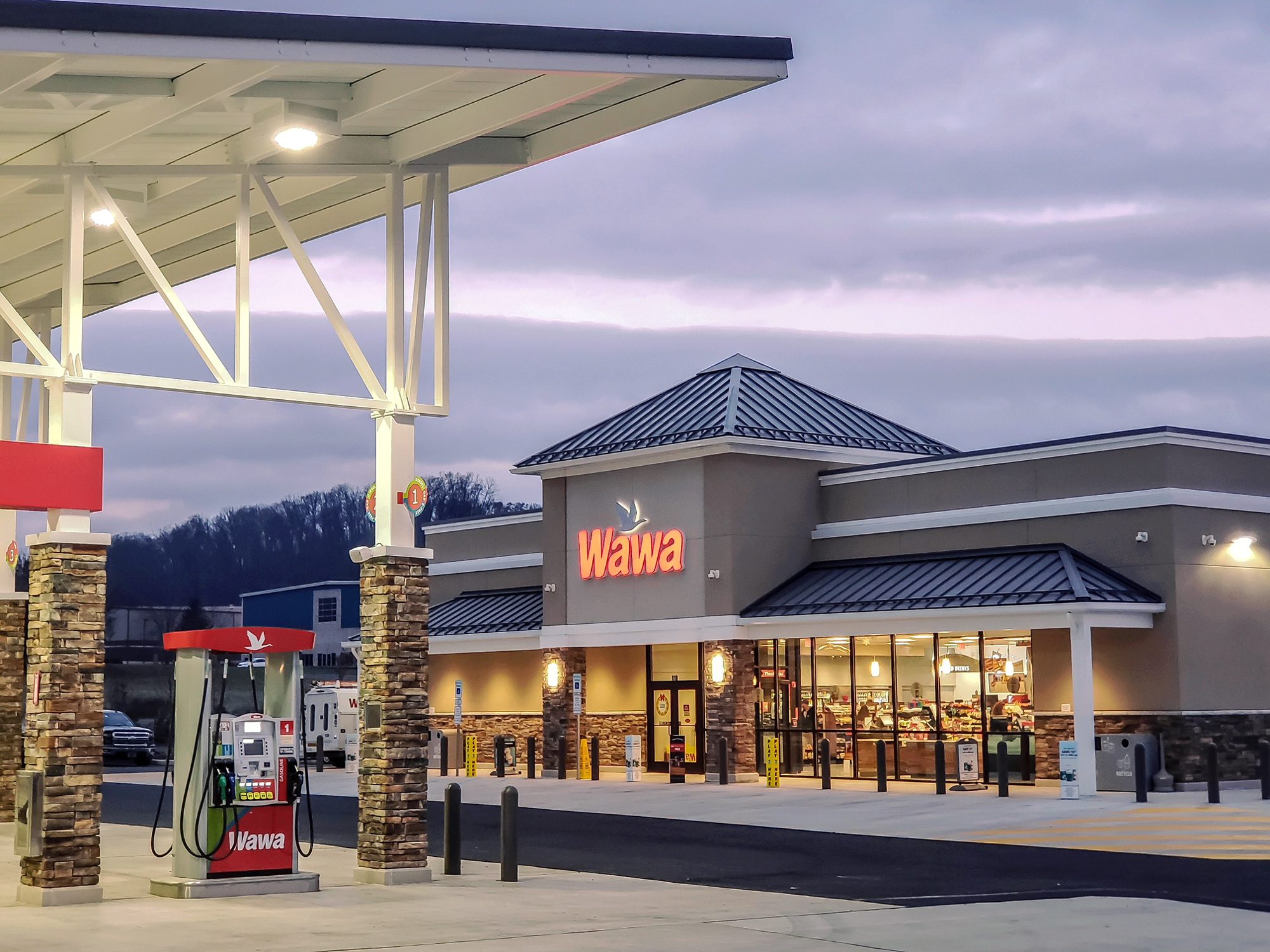 A roadside convenience retail forecourt at dusk
